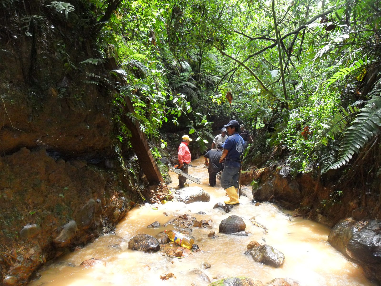 Equipo de trabajo inspeccionando y limpiando el cauce después de las lluvias