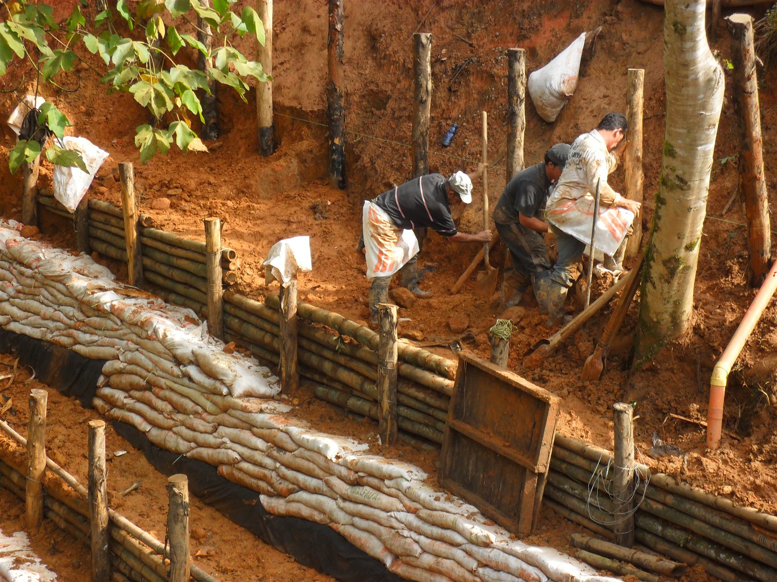 Trabajadores construyendo barreras de contención sobre el talud